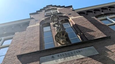 stenen maria beeld boven de entree van ons klooster tegen een strakke zonnige blauw lucht