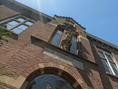 stenen maria beeld boven de entree van ons klooster tegen een strakke zonnige blauw lucht