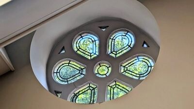 detail van een van de vele glas in lood ramen, dit keer een rond design dat vanaf de straat zichtbaar is