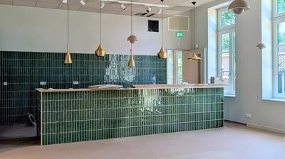 vooraanzicht van de wat de bar gaat zijn horecagedeelte de refter, er wordt nog flink aan geklust en gewerkt, het is nog niet af, wel hangen de gouden lampen al en zijn de smaragdgroene tegeltjes geplaatst