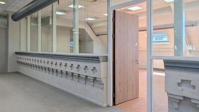 een aanzicht van een van de vele zalen met originele oude muur met kruizen en nieuw geplaatst glas